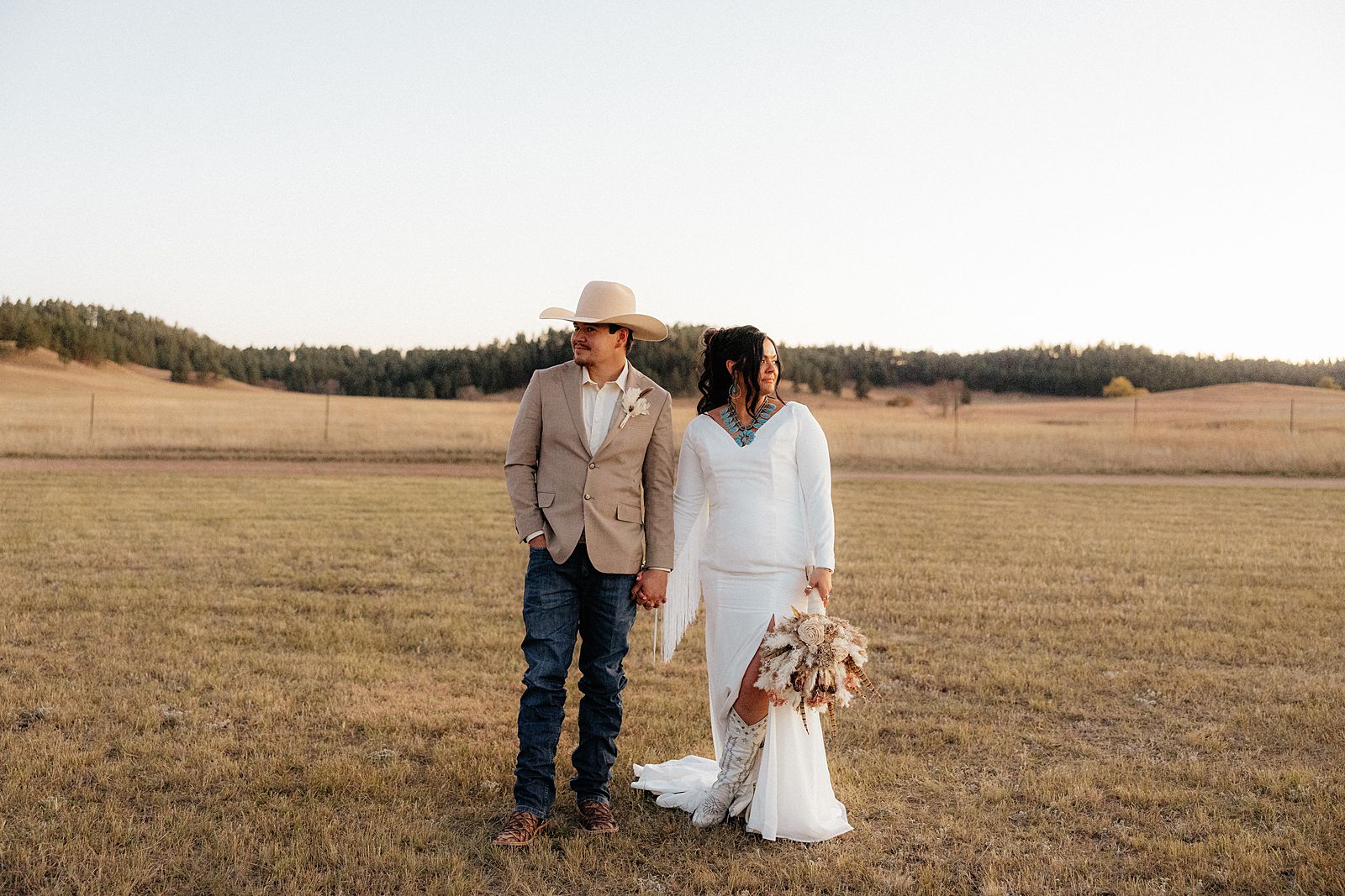 The bride and groom looking in opposite directions at their bohemian style wedding.
