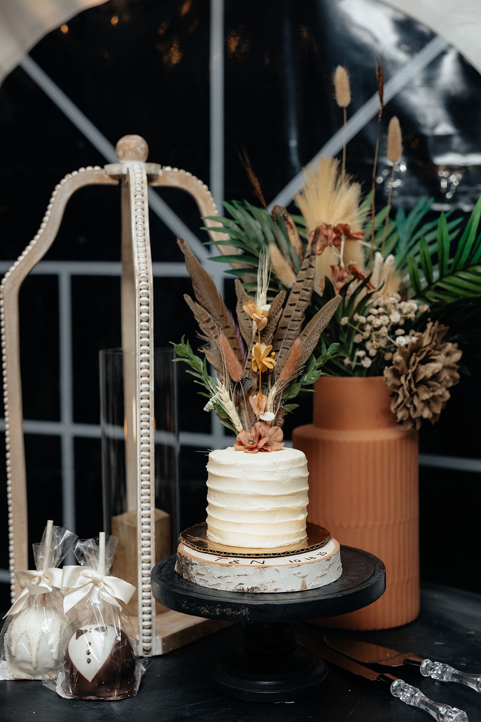 A bohemian style wedding cake with pheasant feathers.