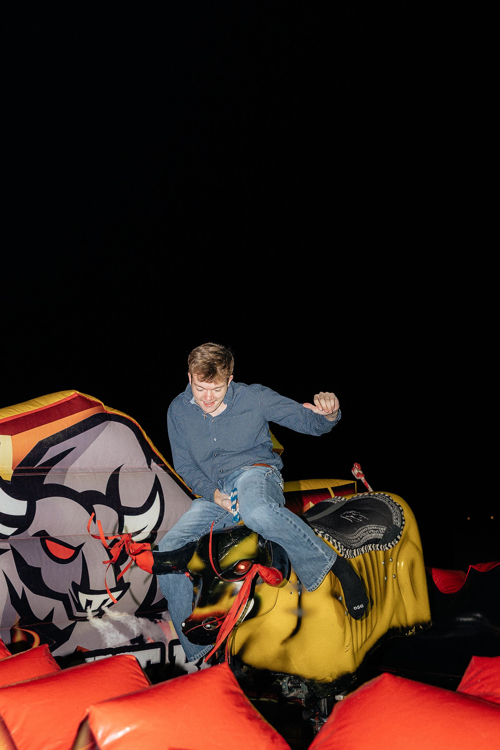 A guy falling off a mechanical bull.