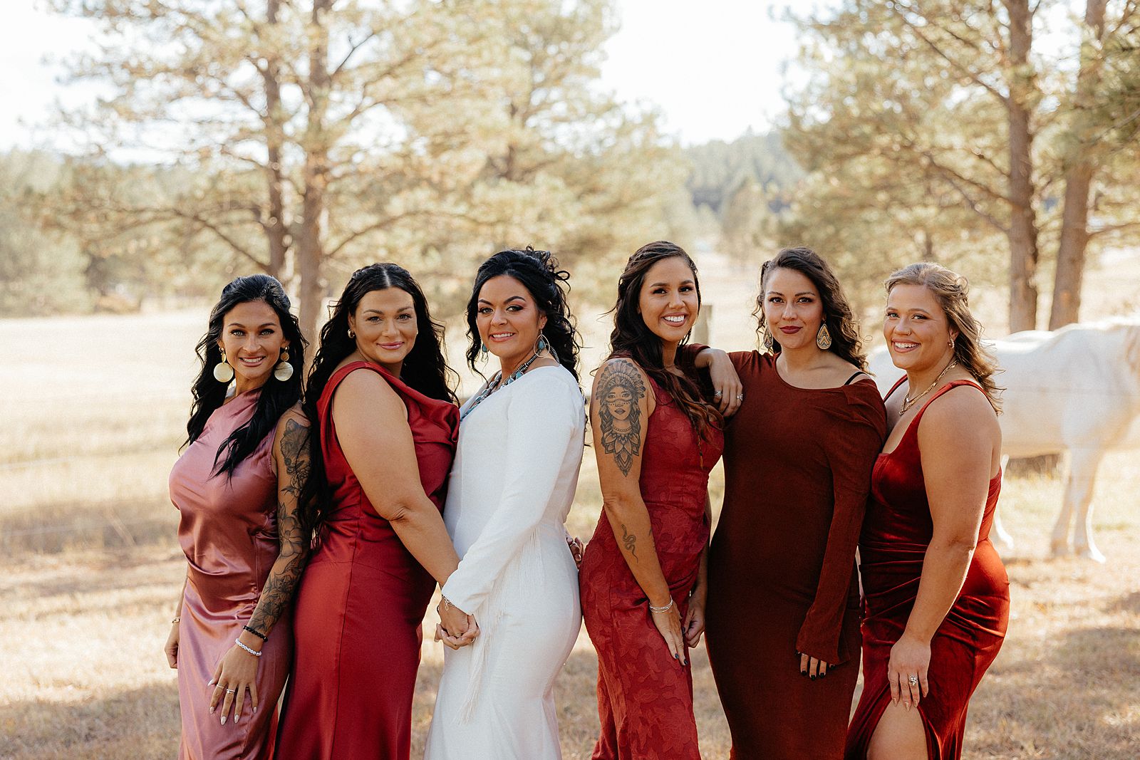 Bridesmaids in red dresses at a campground wedding.