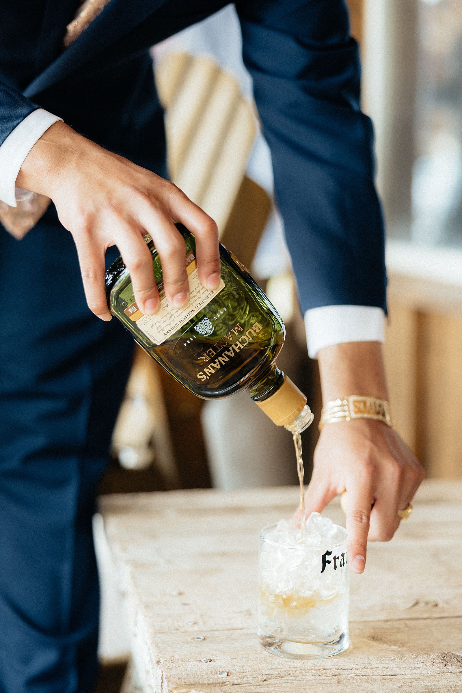 The groom pouring Buchanan's Master.