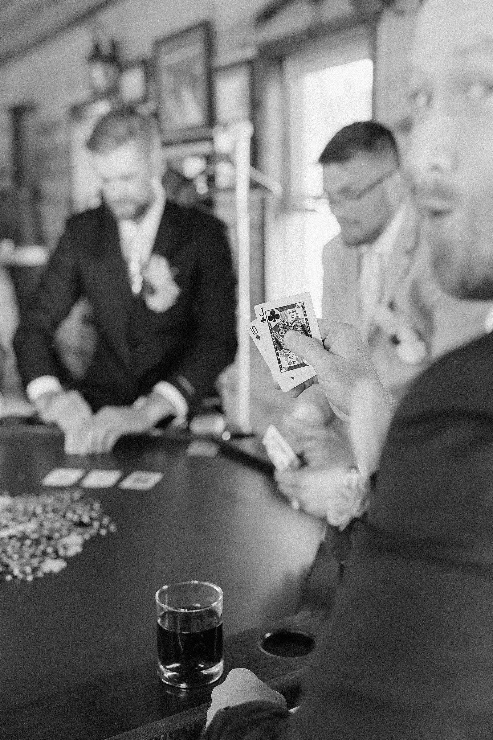 A groomsman showing his cards to the camera.