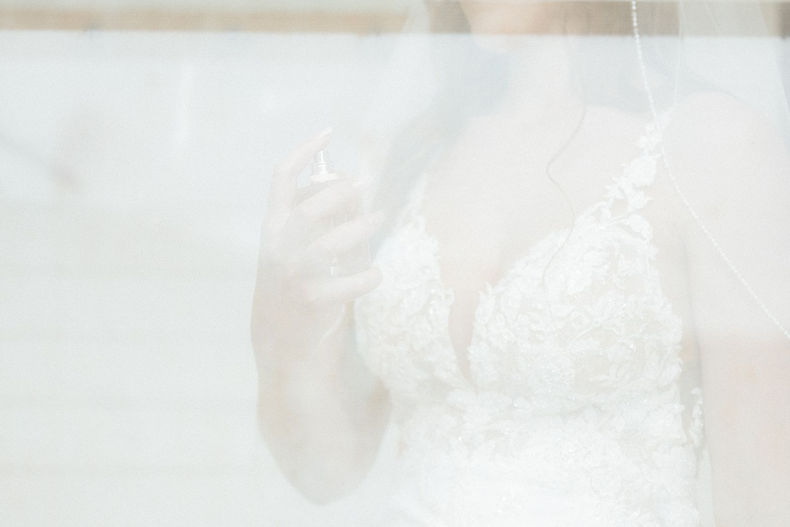 The bride putting on her perfume.