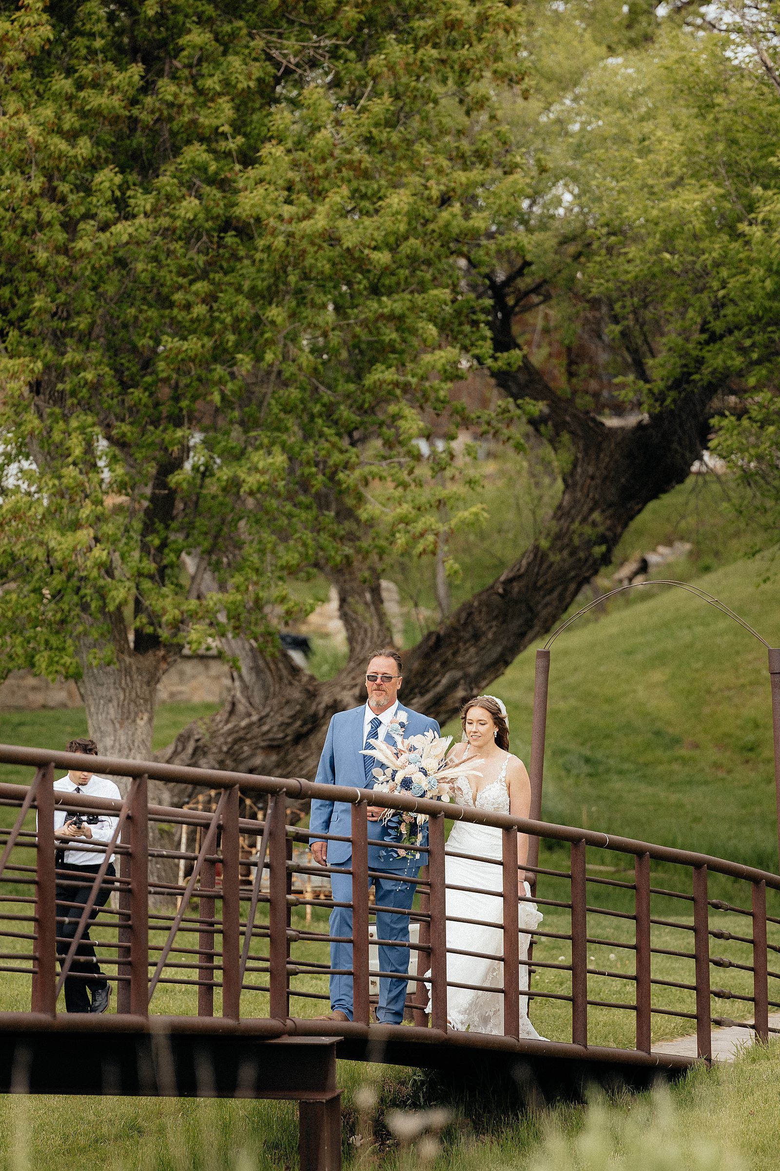 The bride walking across the bridge to her groom at Besler's.