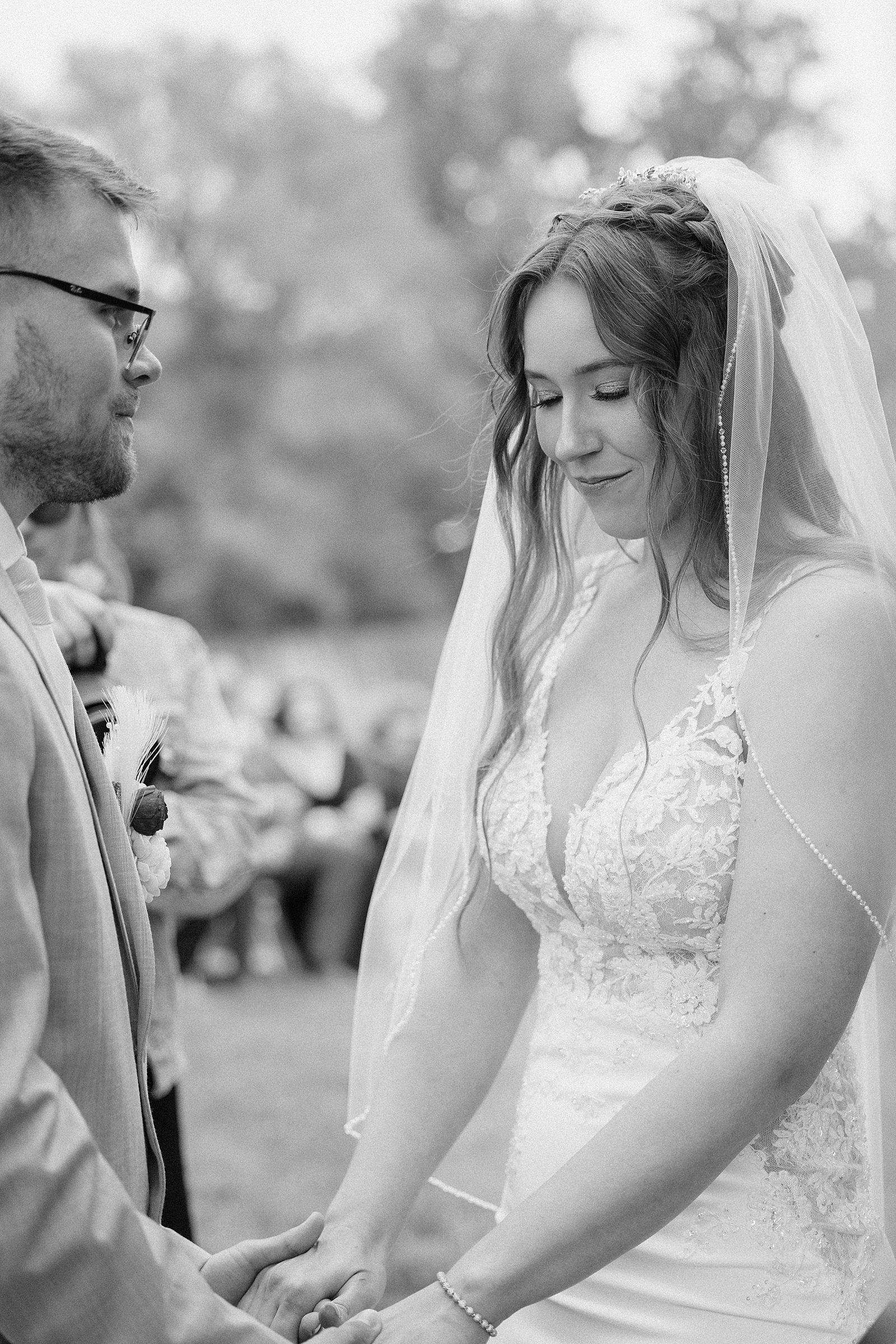 A bride bowing her head during prayer during her Besler's Cadillac ranch wedding ceremony.