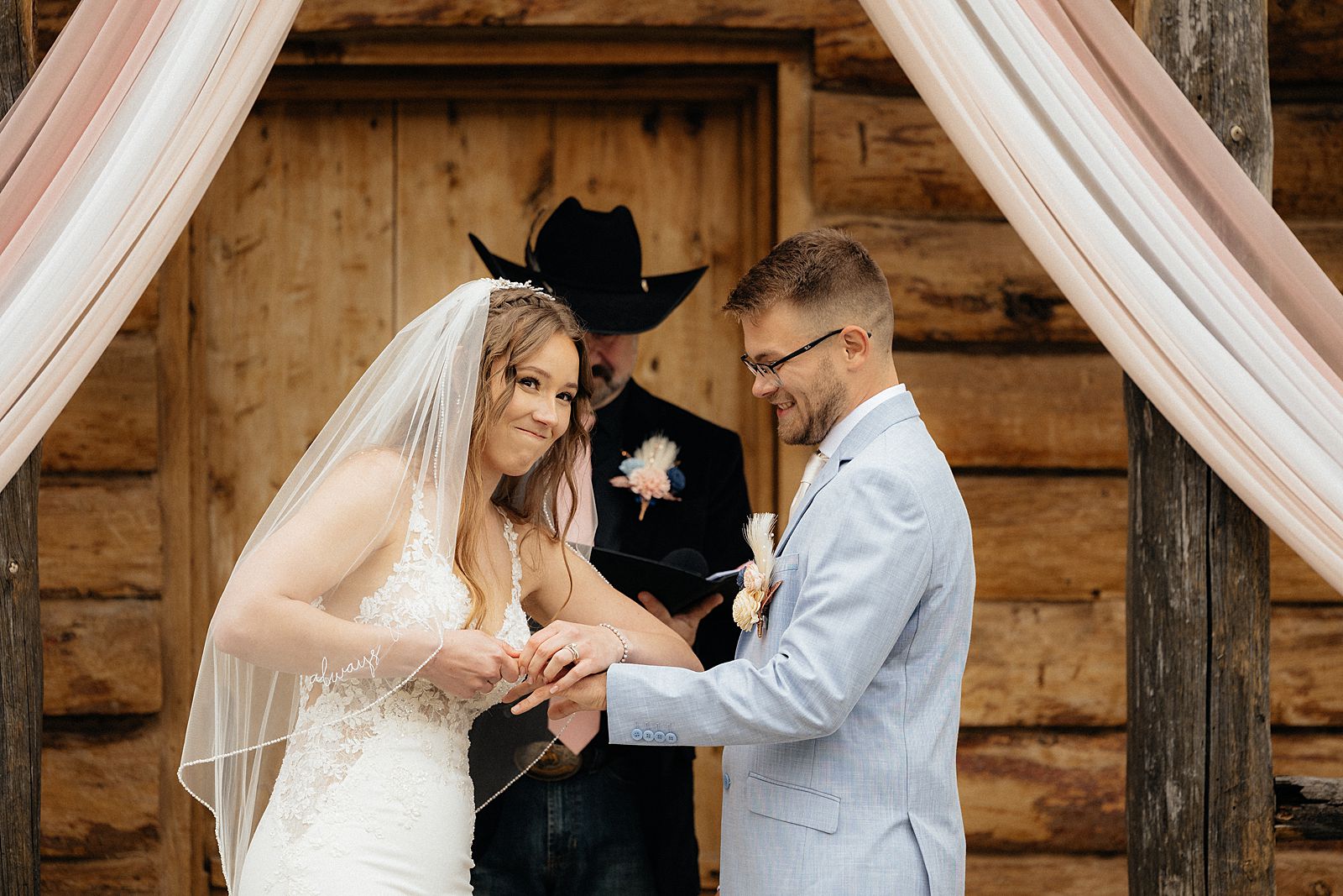 The bride struggling to put on the groom's ring.