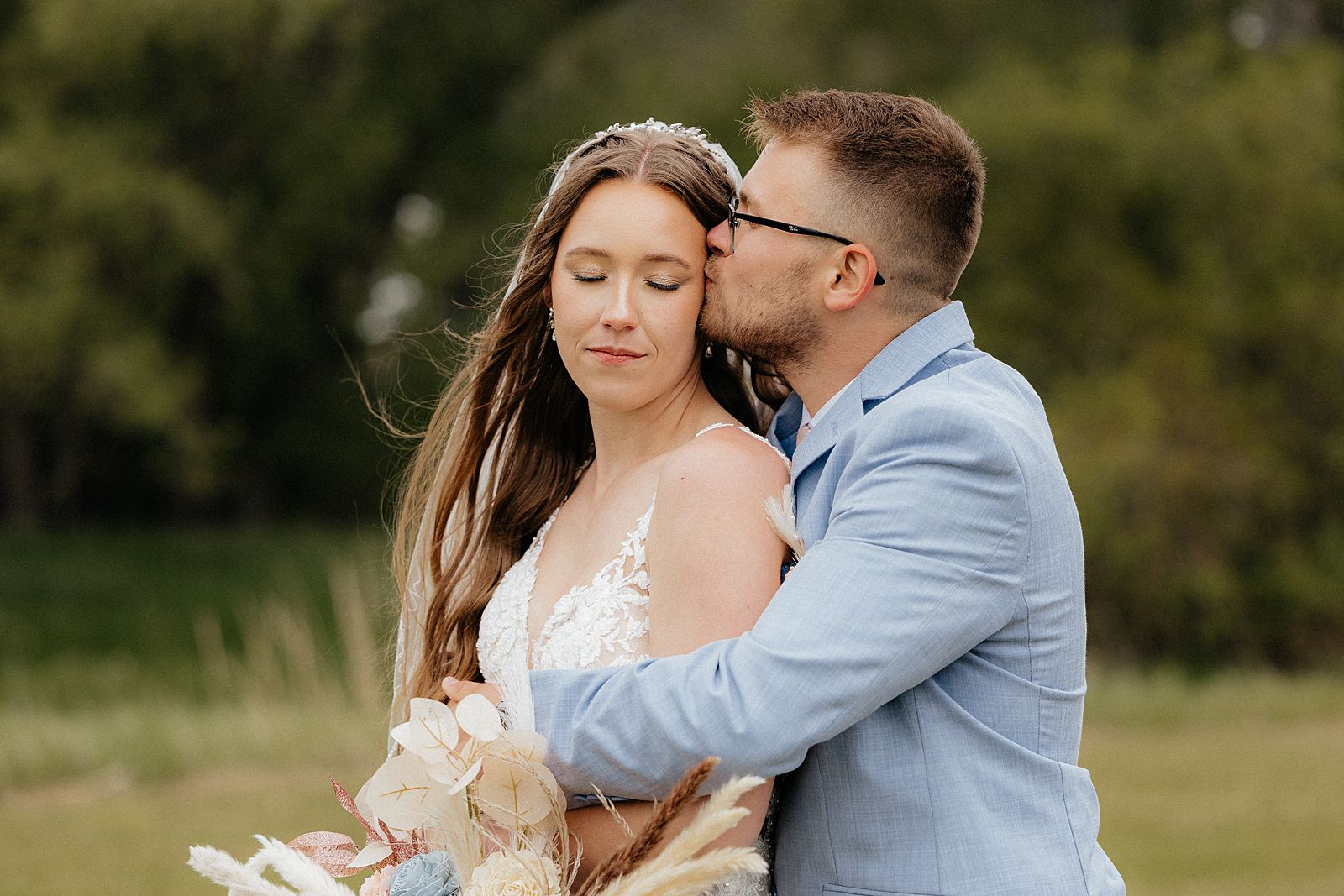 The groom kissing the bride's temple. Photo taken by a South Dakota wedding photographer.