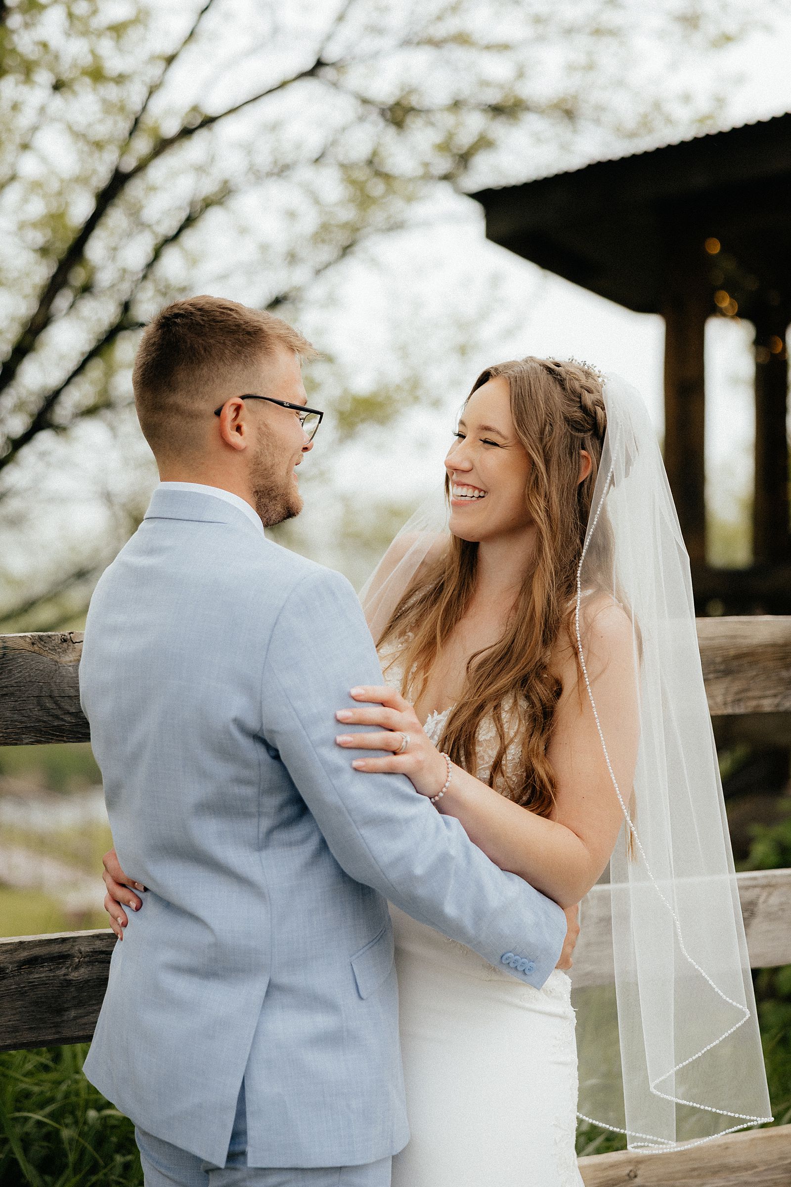 The bride and groom smiling at each other during golden hour.