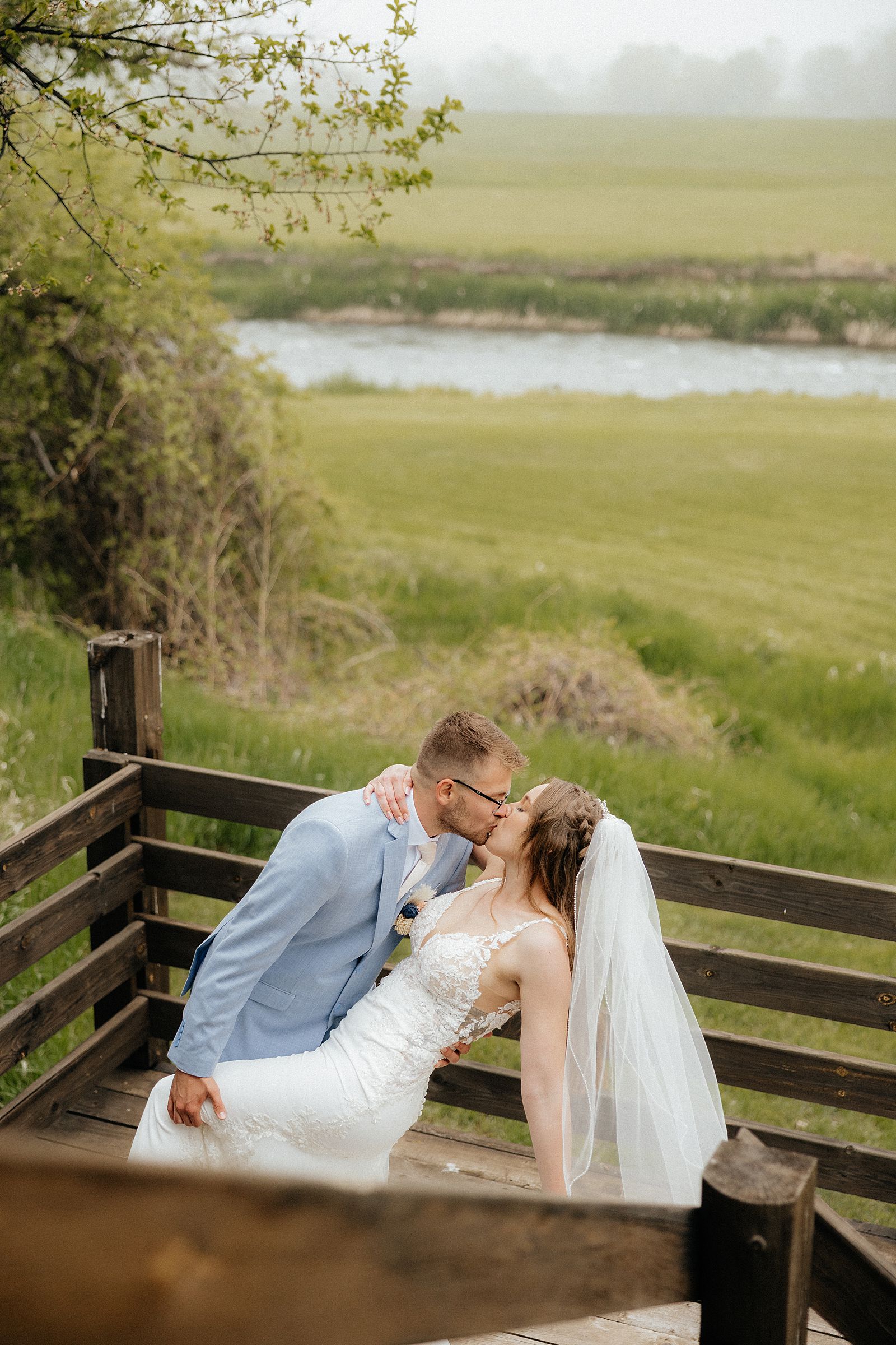 The groom dipping the bride at Besler's Cadillac Ranch.