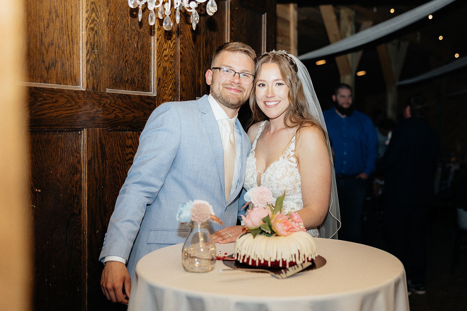 The couple smiling with their wedding cake.