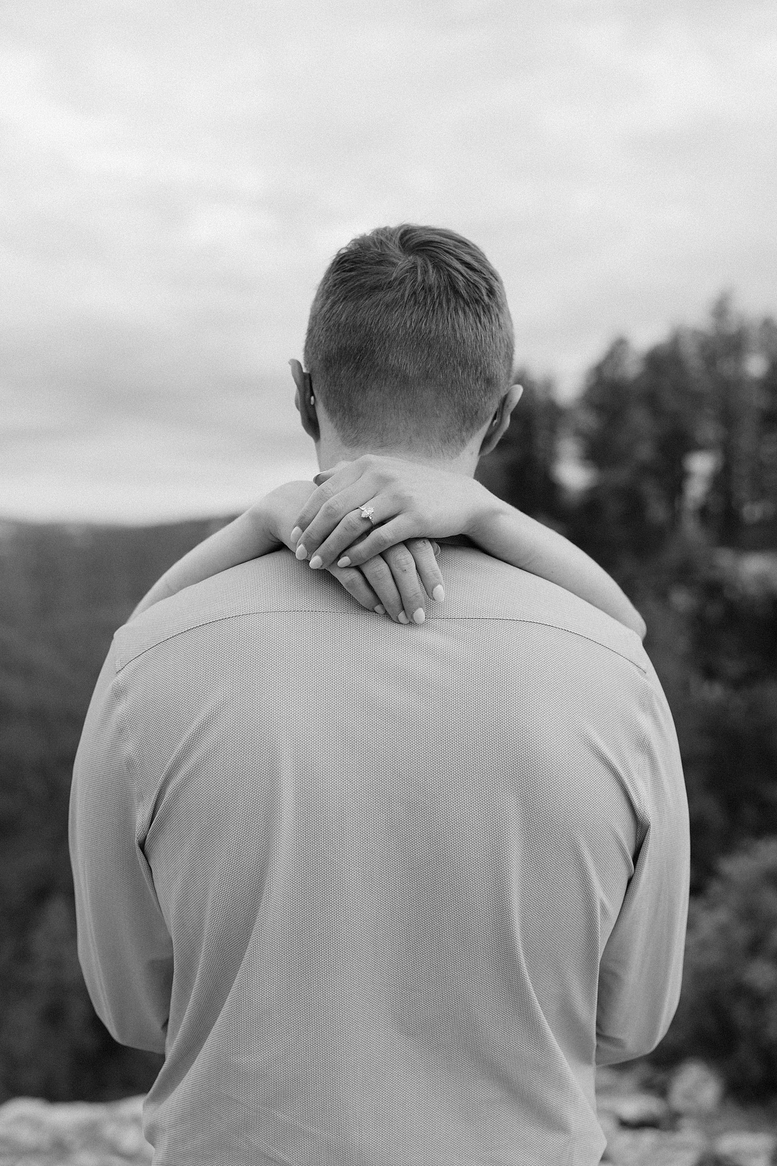 Avery wrapping her arms around Devin's neck and showing off her engagement ring.