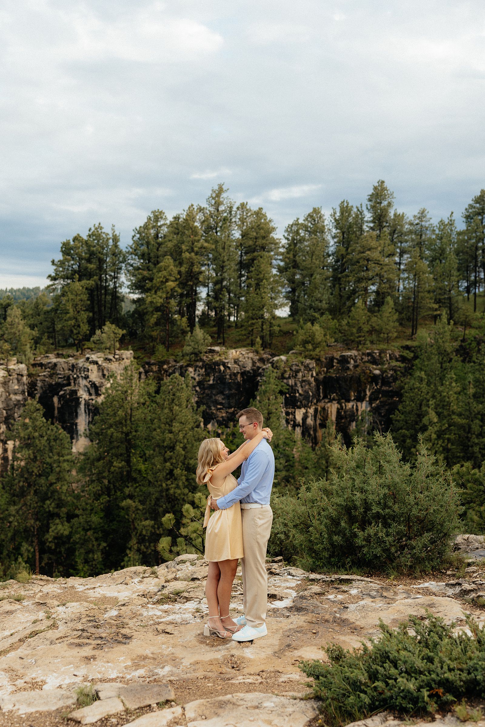 The couple looking at each other with the canyon view in the background.