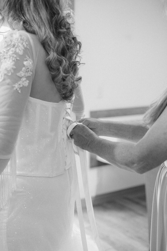The bride getting her dress laced up.