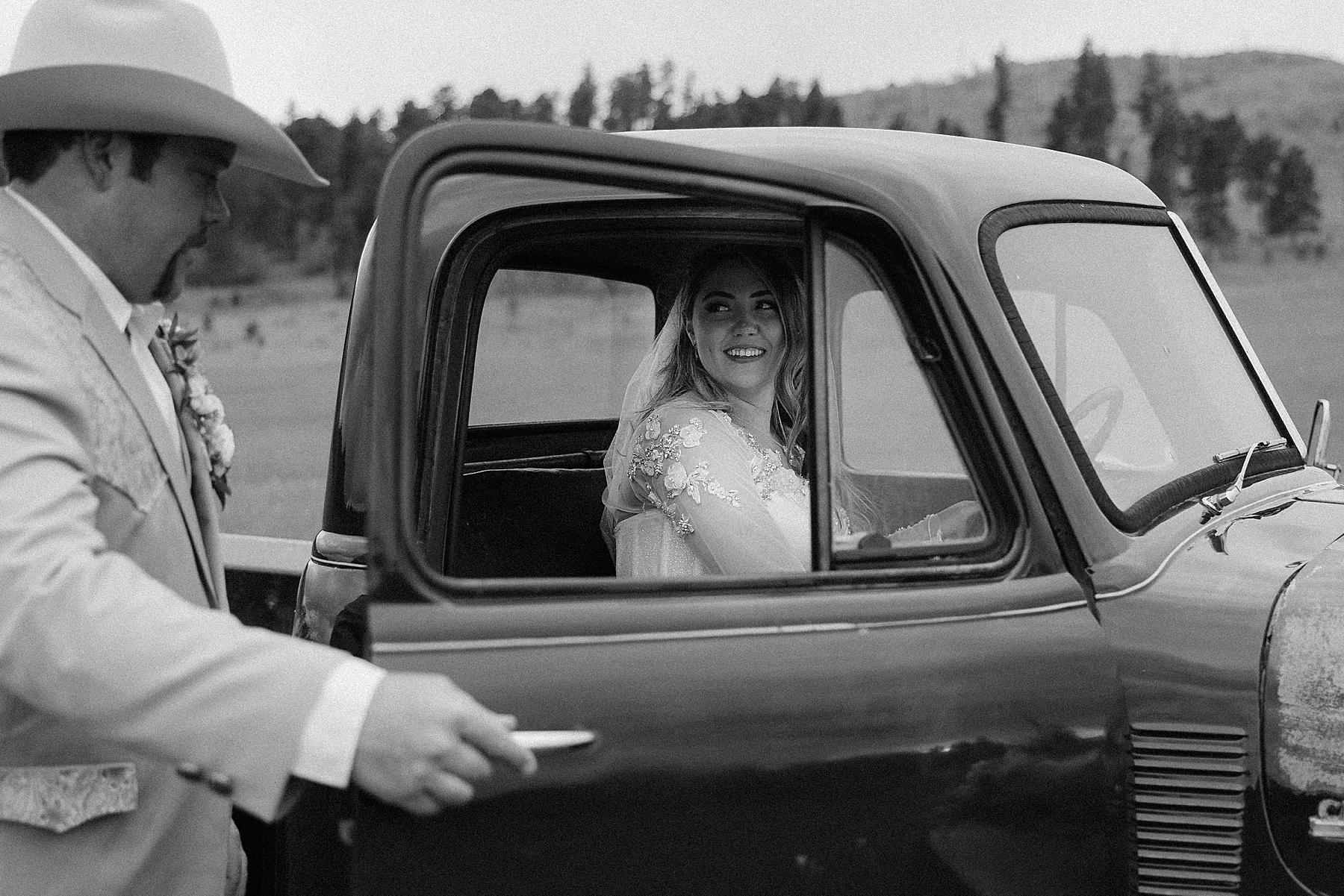 The groom opening the truck door for the bride.