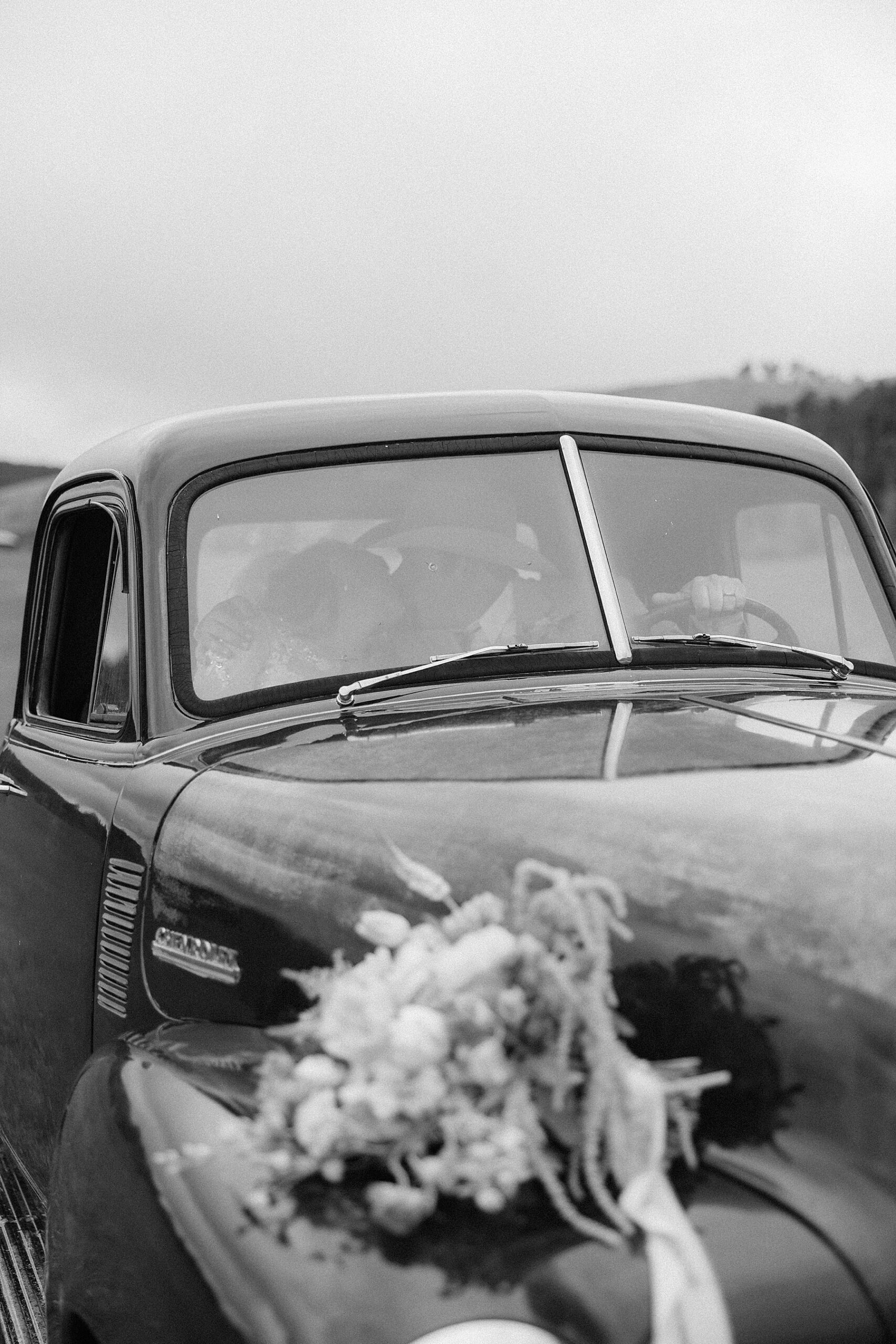 A couple kissing in a vintage chevrolet truck at their Muley Hill Lodge wedding. Photo taken by Rapid City Wedding Photographer.