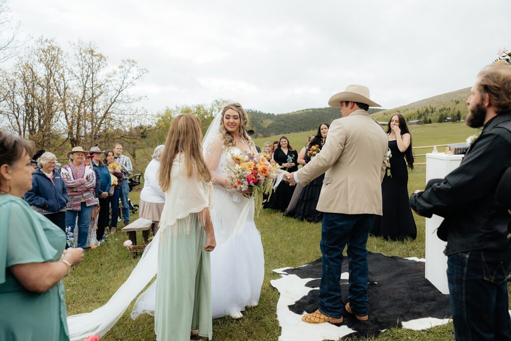 The mother and father of the bride giving her away at the alter.