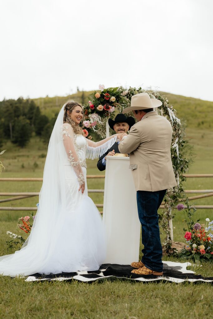 The groom putting on the bride's ring.
