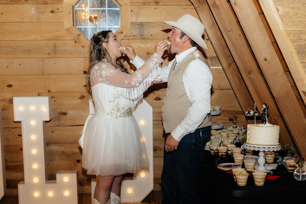 The bride and groom feeding each other cake.