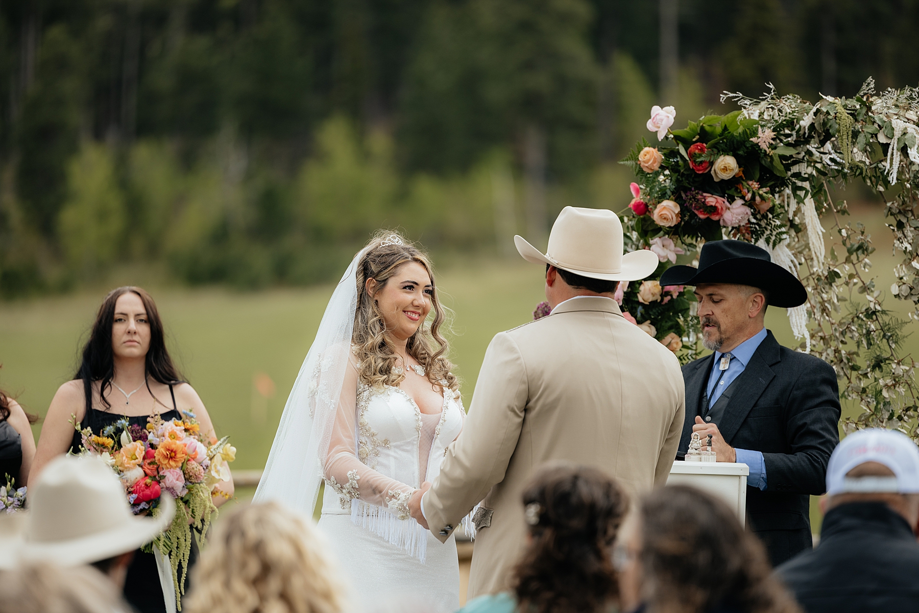 A couple smiling at each other at the alter, at their Muley Hill Lodge wedding.