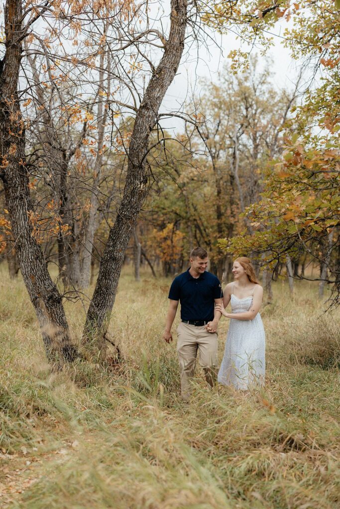 A couple walking down a trail at their engagement session.