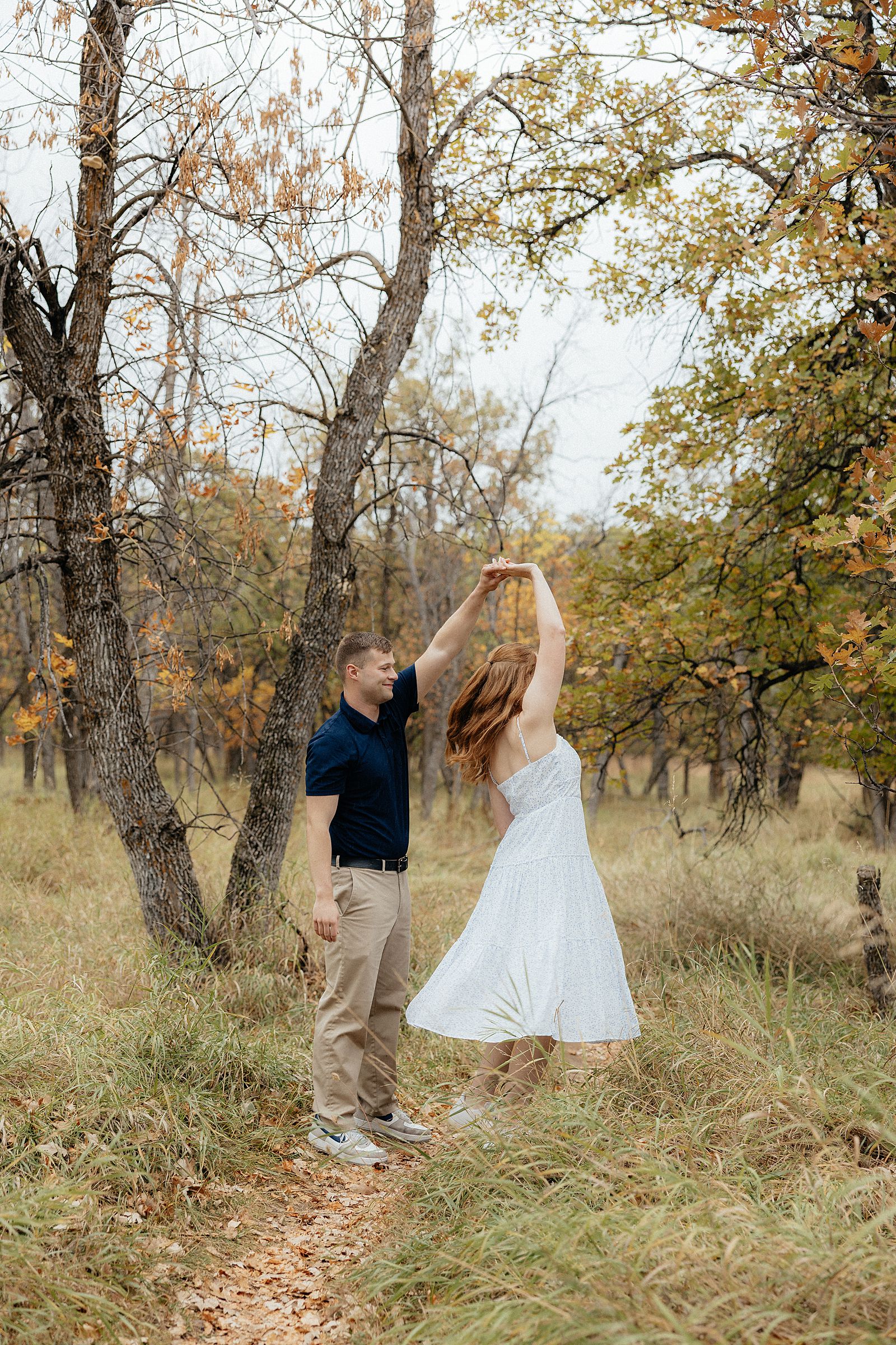 Warren spinning Olivia with a fall backdrop.