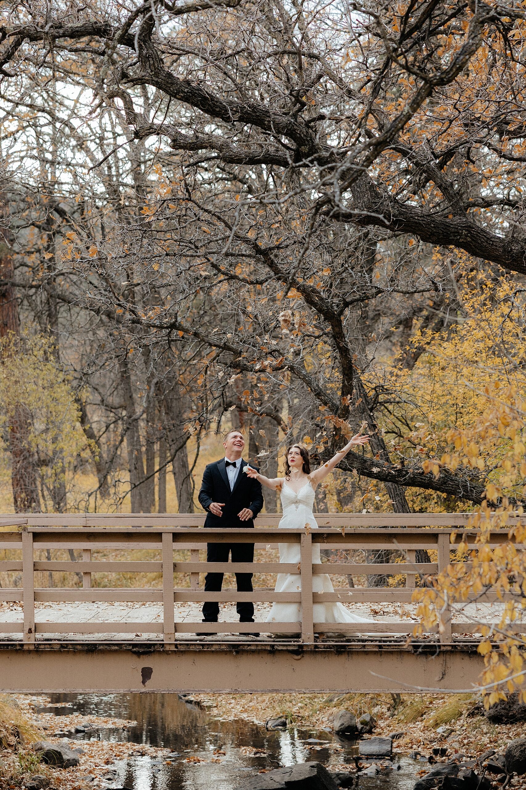 A couple throwing leaves off a bridge at the Custer State Game Lodge.