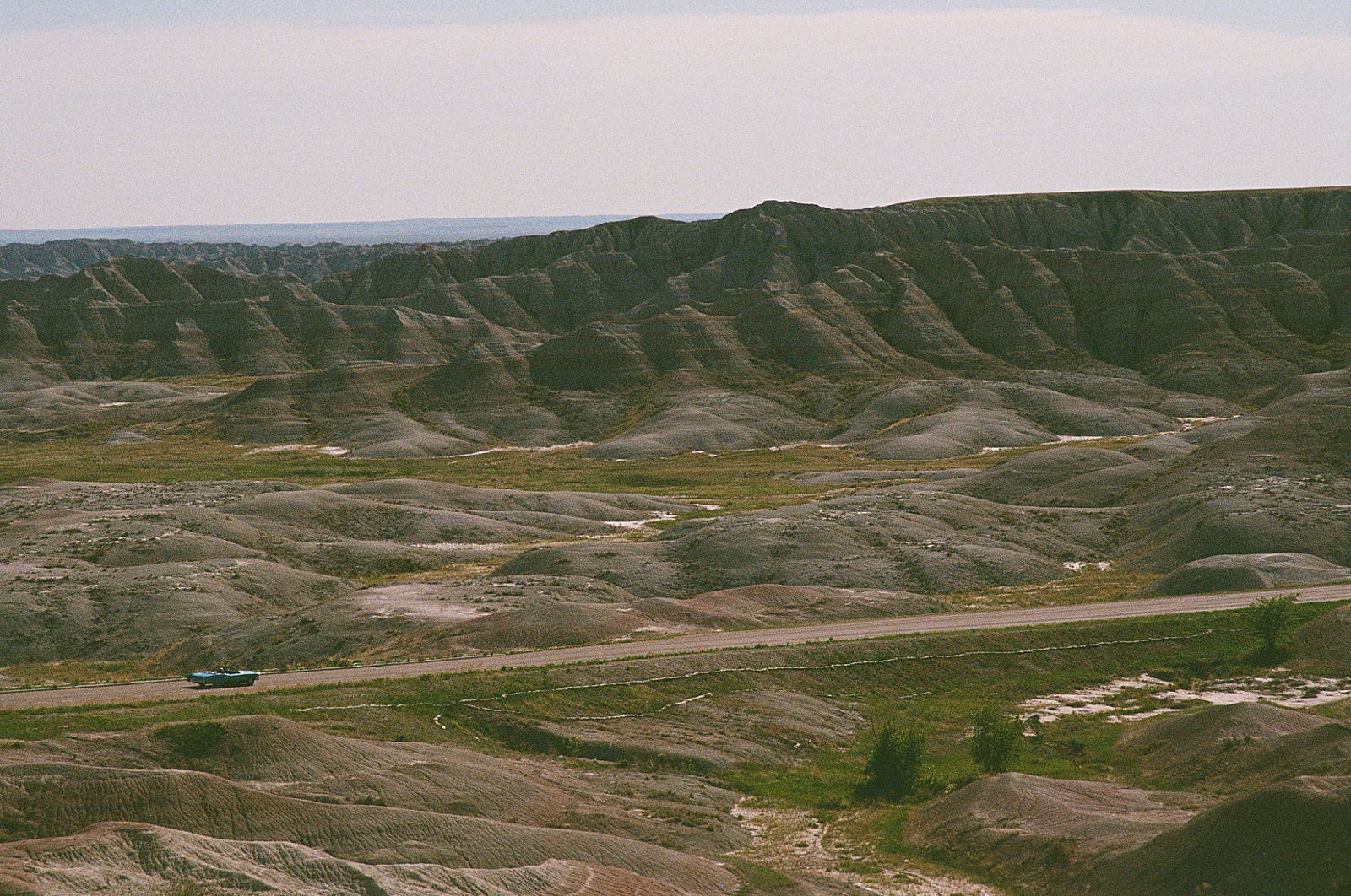 A car driving near Bigfoot Pass Overlook in Badlands National Park.