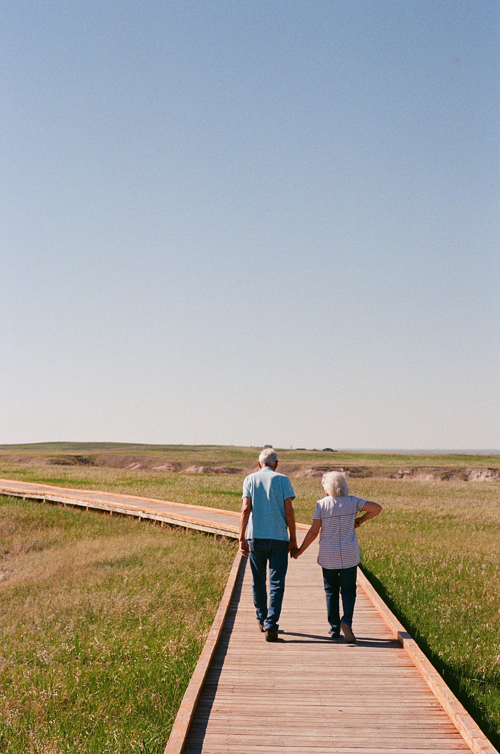 Grandparents walking on a boardwalk trail in Badlands National park.