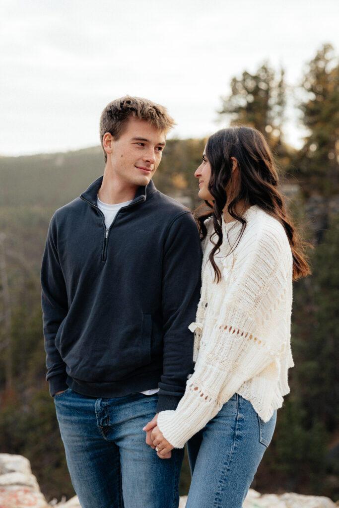 A couple smiling at each other during their engagement session.