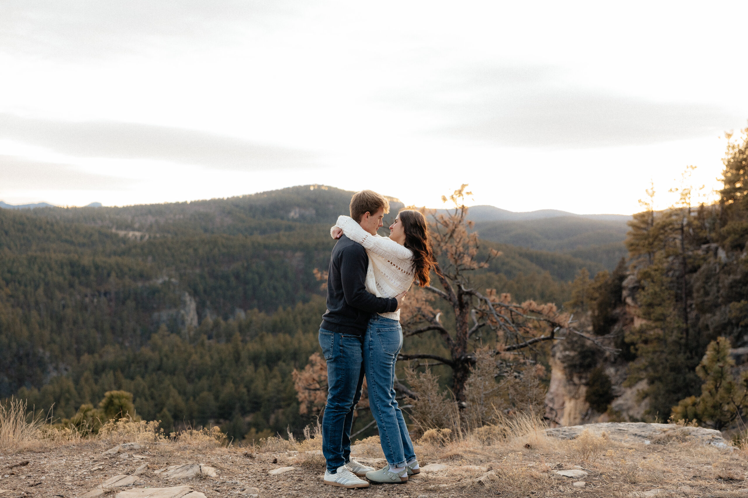 A couple with a view of the Black Hills behind them.