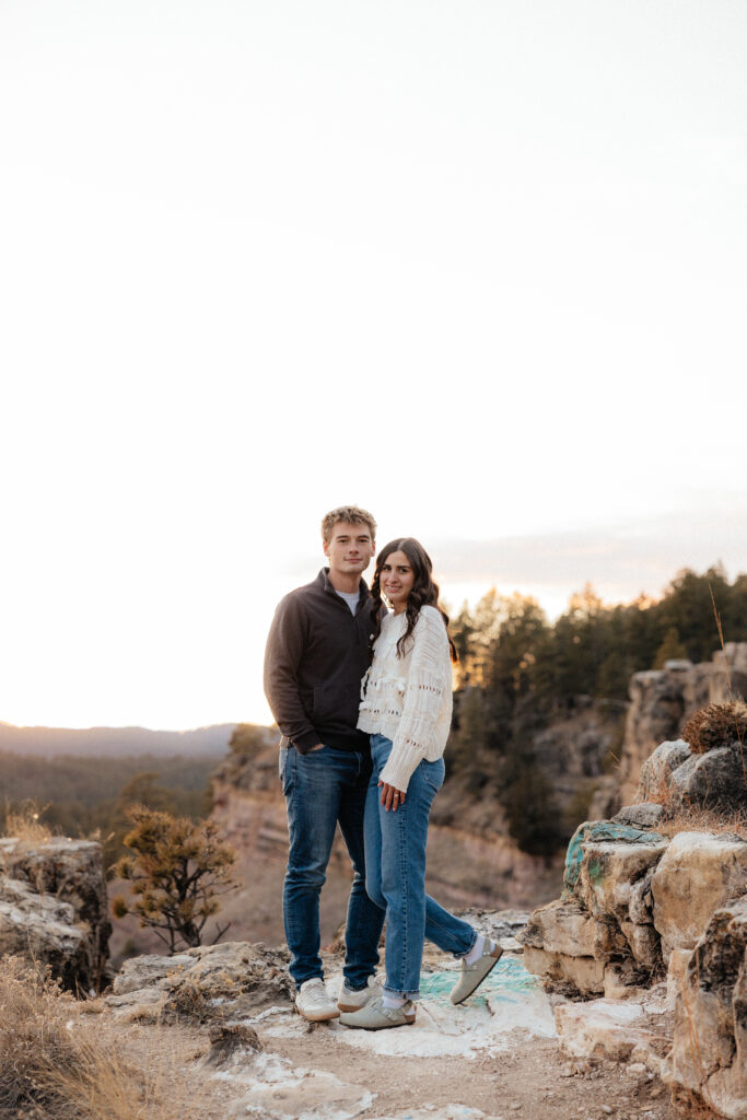 A couple smiling at the camera during their engagement session.