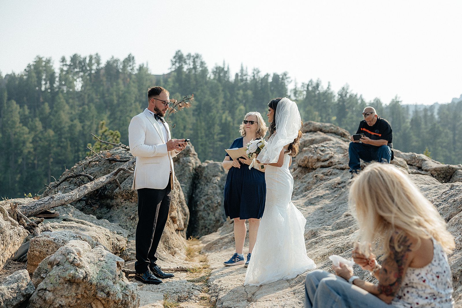 Phoebe and CJ standing together during their outdoor Sylvan Lake wedding ceremony