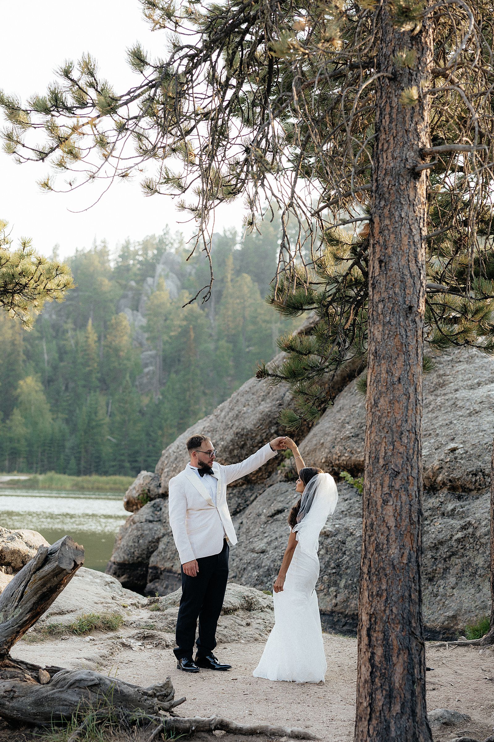Newly married couple standing among granite rocks at Sylvan Lake
