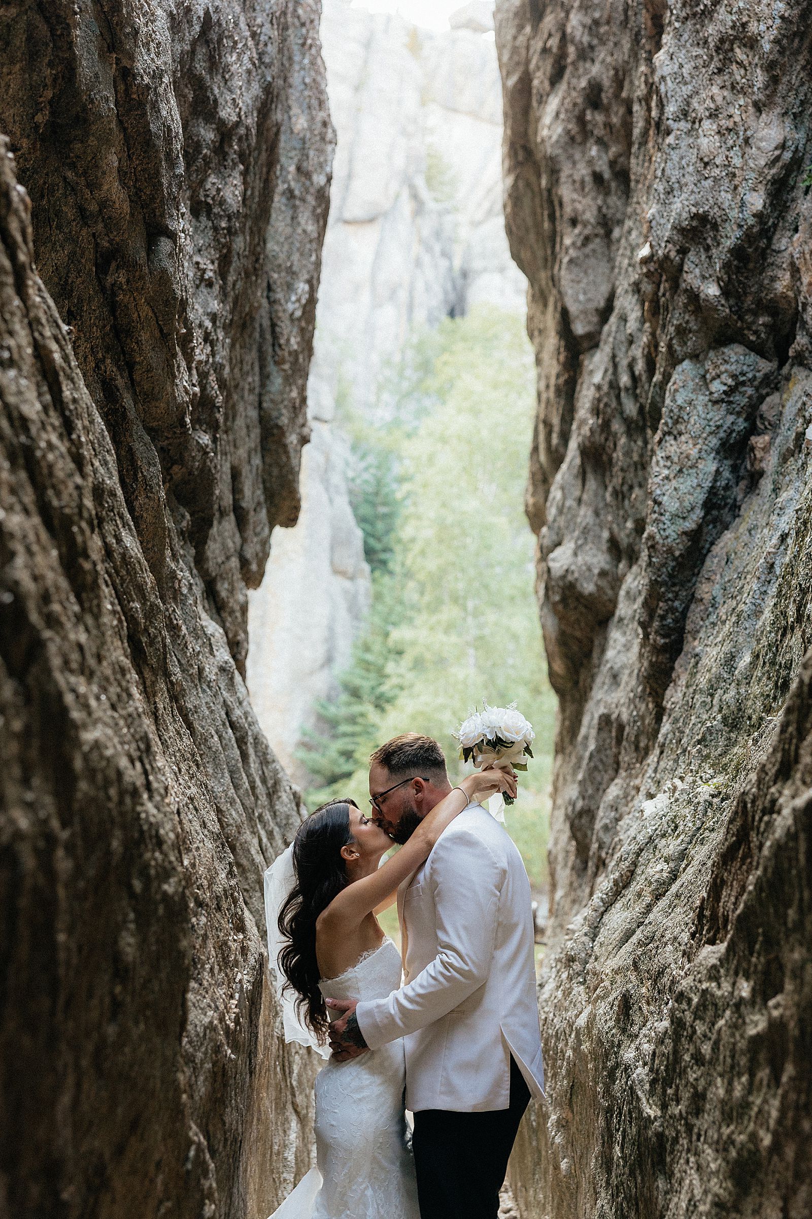 Phoebe and CJ kissing in the granite tunnel on Sunday Gulch trail at Sylvan Lake